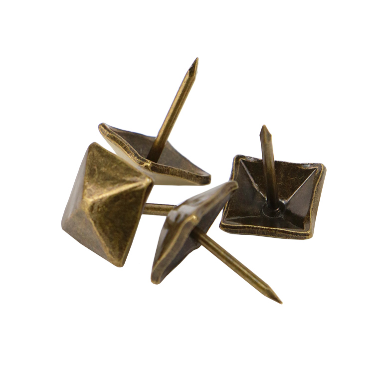 Detailed macro view of the faceted and hand-hammered nail head textures reflecting light